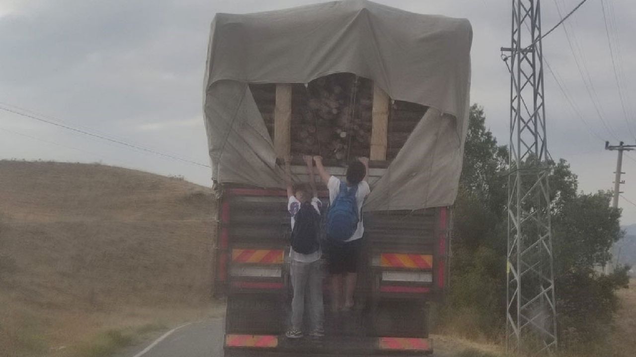 Odun yüklü kamyonun arkasında çocukların tehlikeli yolculuğu