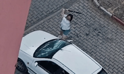 Park halindeki otomobilin camlarını kıran kadın kamerada