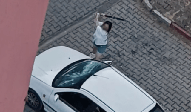 Park halindeki otomobilin camlarını kıran kadın kamerada